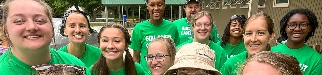  girl scout staff or volunteer wearing adult vest in woods smiling 